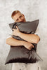 man is hugging his pillow and smiling