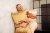 man holding pink and gold pillows