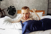 man is hugging his pillow and smiling